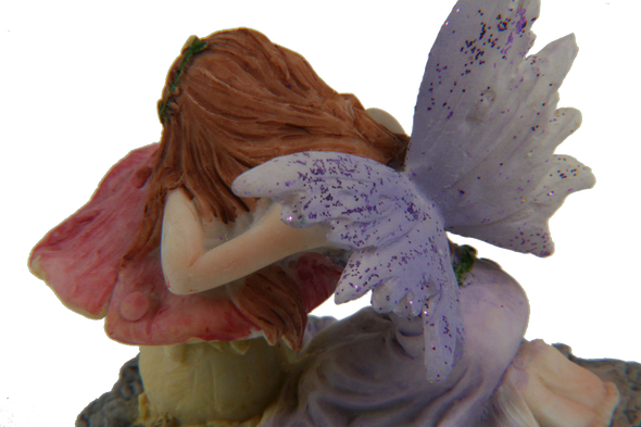 purple and pink miniature fairy on mushroom